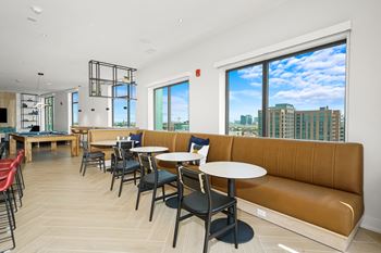 a communal seating area with tables and chairs in a restaurant with a city view at Inspire West Town, Illinois